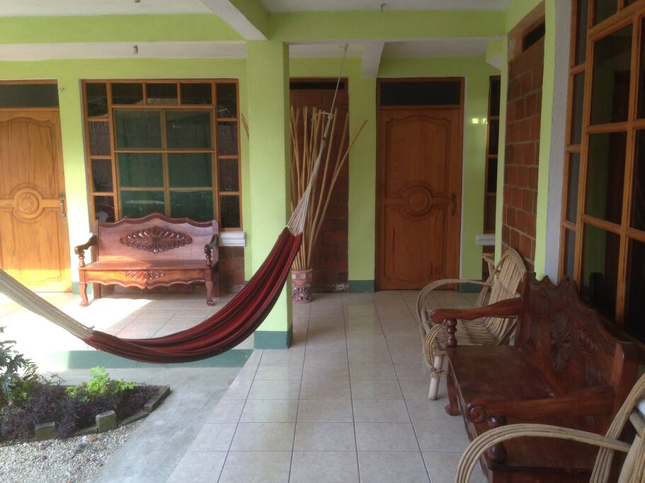 2 hammocks, colonial style furniture, flowery garden.