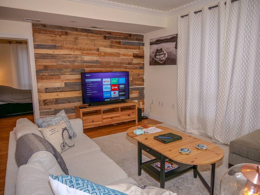 LOVELY wooden pallet wall with 55' Flatscreen TV, including Samsung soundbar and subwoofer. Television includes Netflix, Amazon Prime, and YouTube.