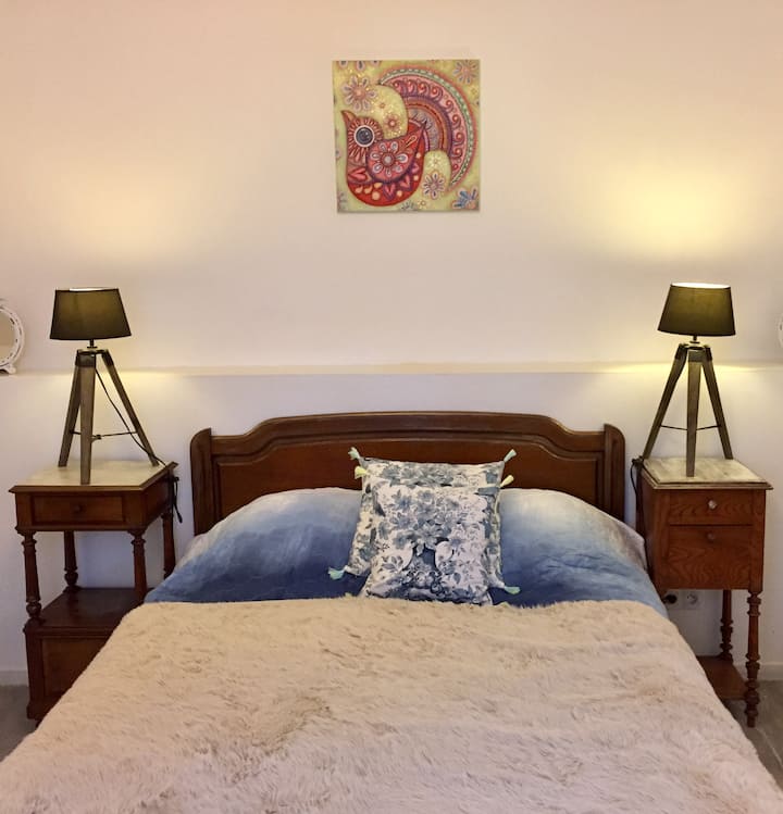 Krevat dopio, tavolina pranë krevatit, abazhurë dhe me prizë në të dyja anët.