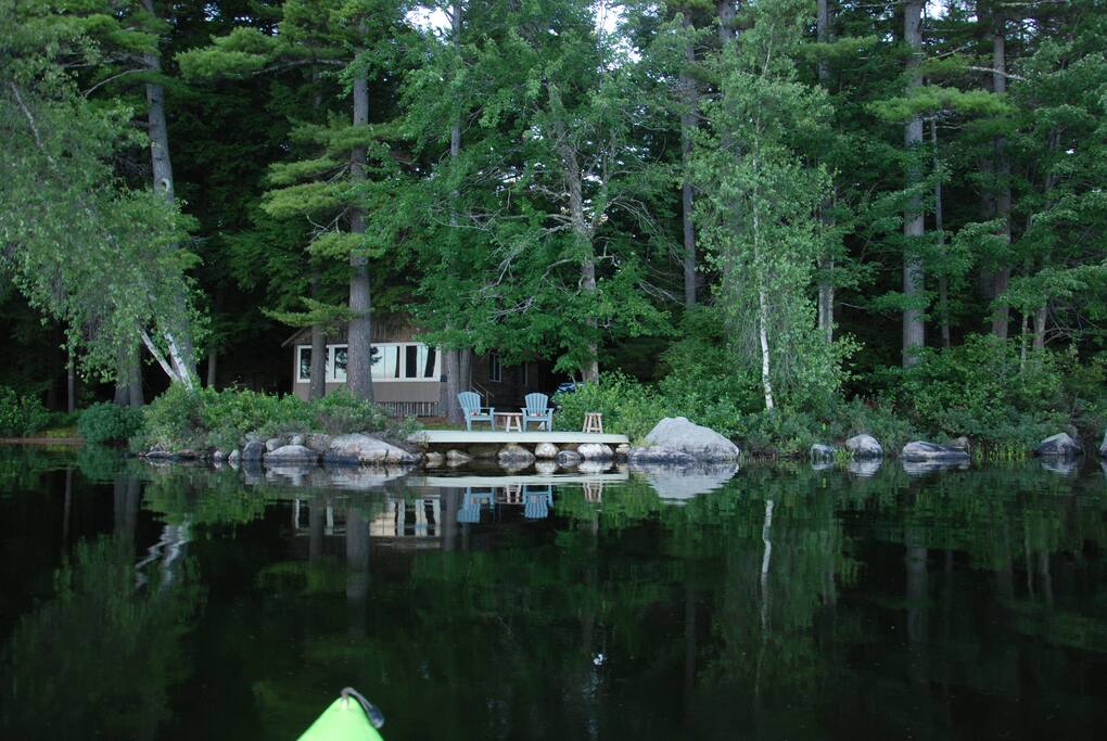 View of cabin nestled among the pines from the lake.