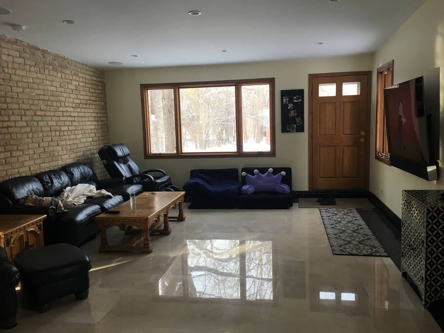Family room with couch, futon, arm chair, massage chair and large TV