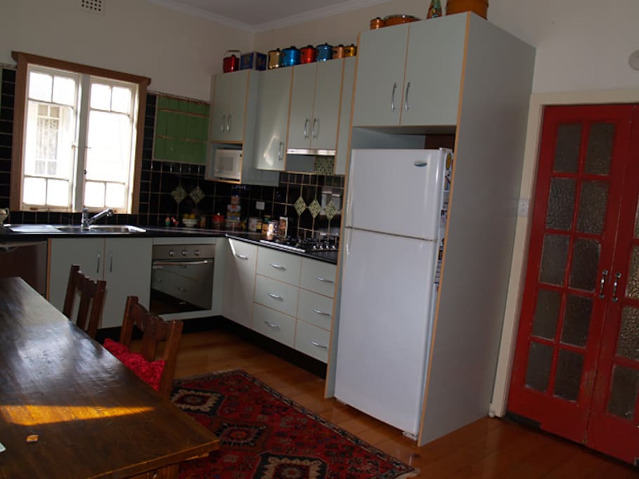 This is an older photo of the kitchen before I put in a new casement window. There is now a smaller table for 4 in the dining area and my new fridge is larger and stainless steel.