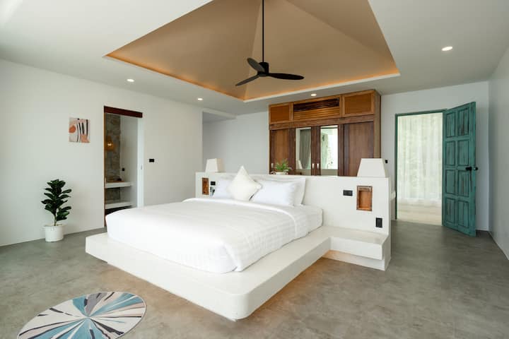 A bedside table holds a soft glow lamp, perfect for late-night reading or adding a touch of ambiance.