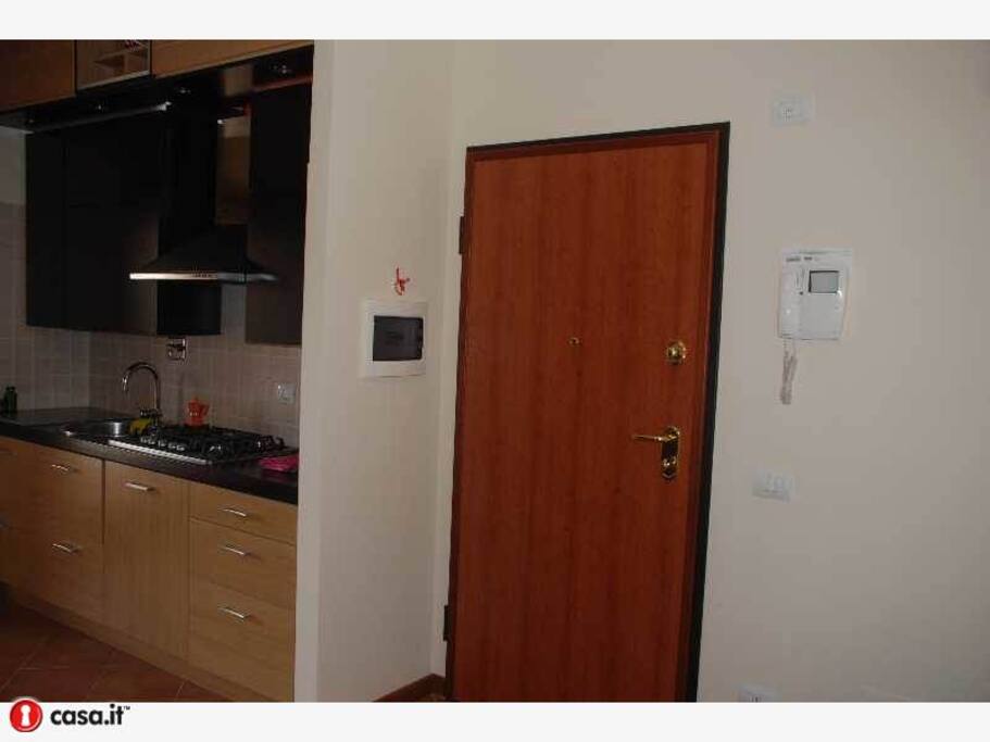 Portone di entrata con parete cucina in vista