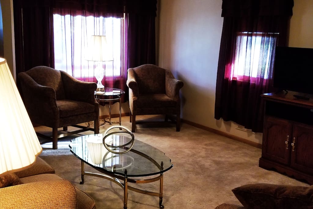 Livingroom with TV, loveseat, couch, and two armchairs.