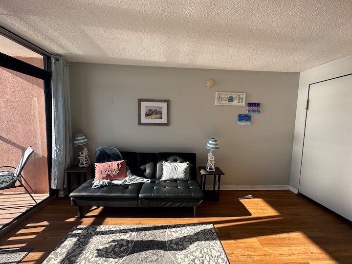 มองจากทีวีไปยังโซฟา สังเกตเห็นเตียงเมอร์ฟี่ที่เก็บไว้ด้านขวา 