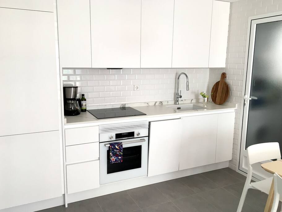 New and fully equipped kitchen with fridge, oven and dishwasher. The door from the kitchen leads to the pateo.