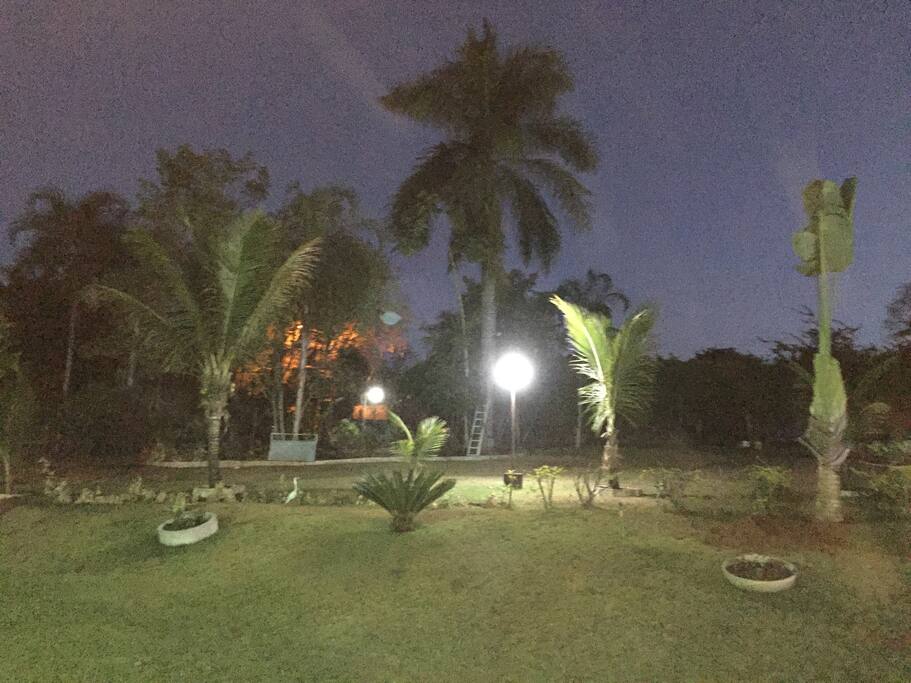 Visão noturna, com iluminação em todo jardim.