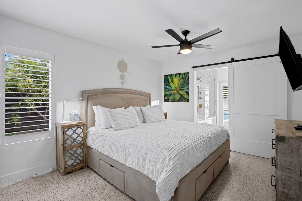 Glavna spavaća soba s bračnim krevetom i TV-om ravnog ekrana 