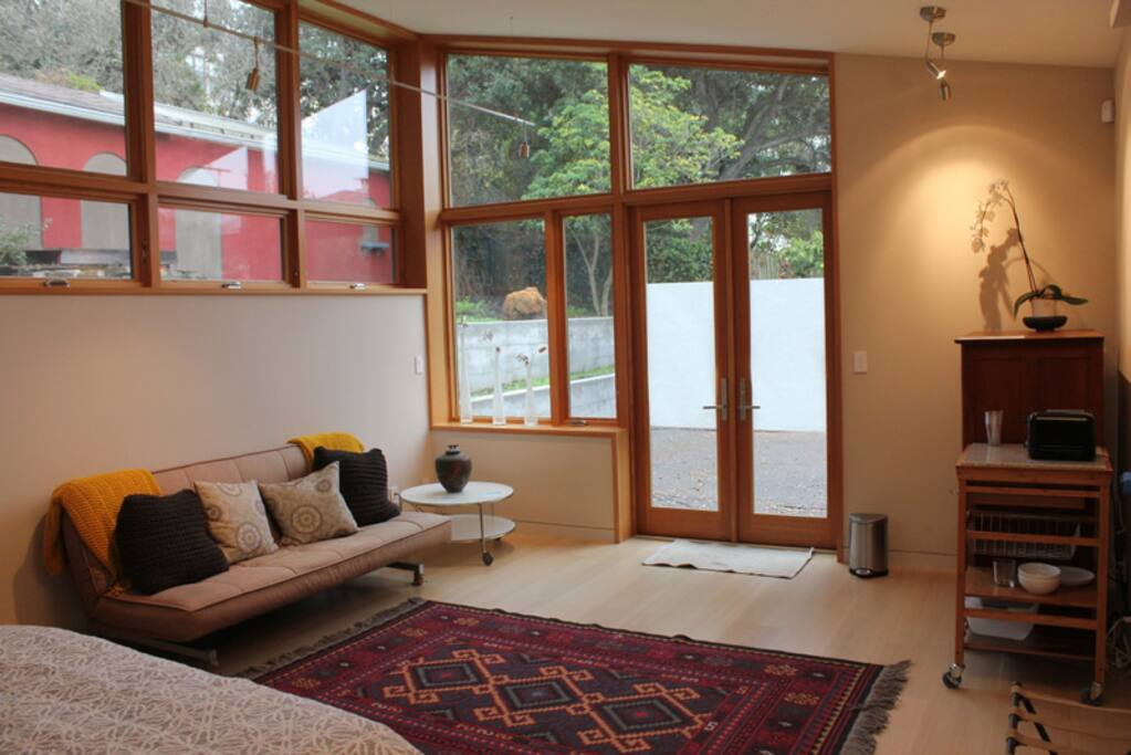 Spacious studio. Sofa on left. Kitchenette area on right.