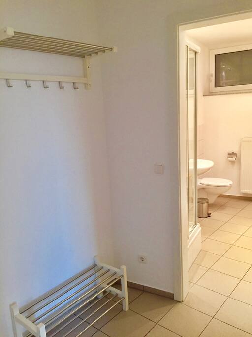 Flur mit Garderobe und Blick ins großzüge Bad mit Dusche (8 qm)