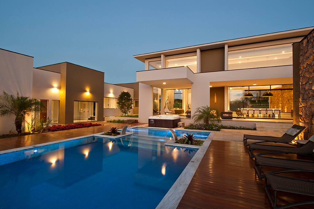 Piscina da casa com iluminação noturna.