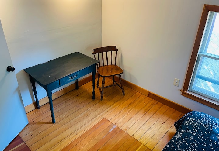 dormitorio más pequeño: escritorio y persianas en las ventanas