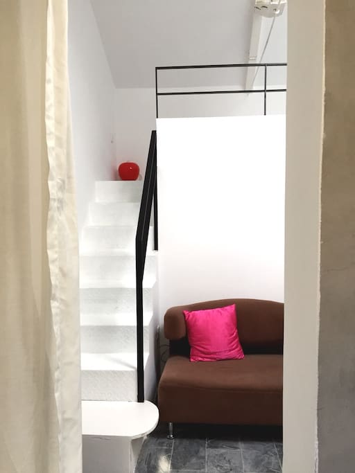 Sofa is big enough for two persons. Stairs lead to the bed on upper floor.