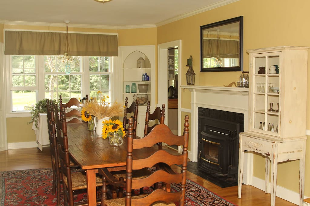 Our dining room features antique furniture and a working fireplace. An additional sun porch for dining is attached but not seen here.