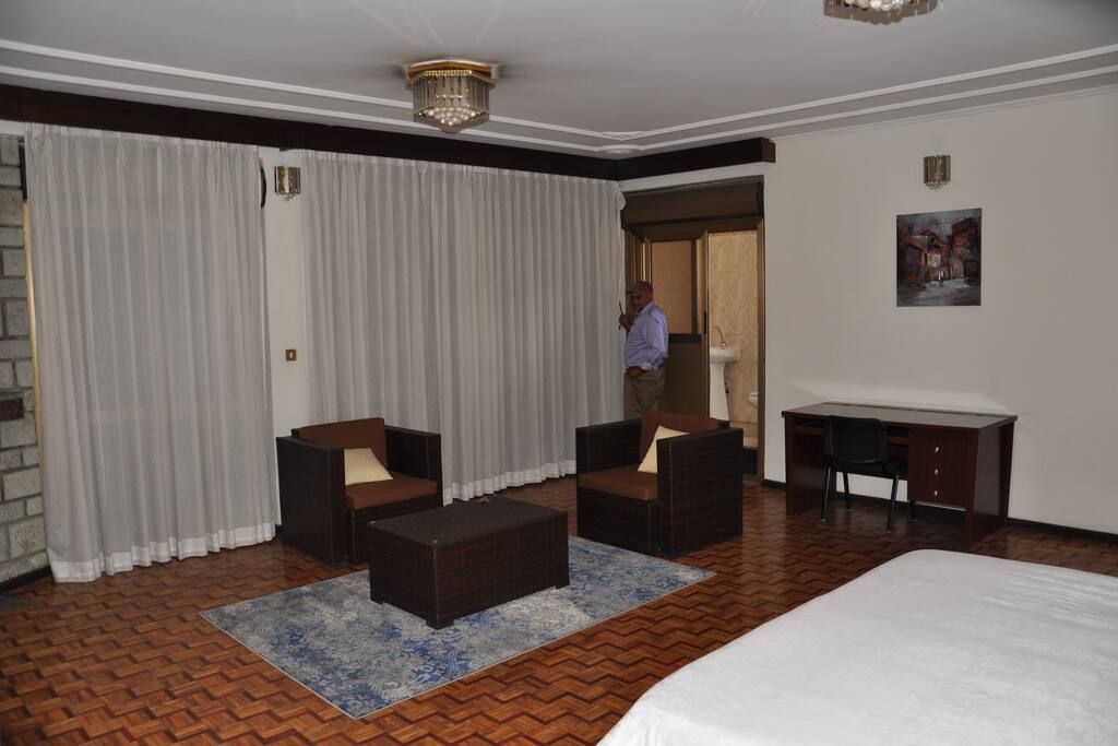 Bedroom with lounge area and office desk. As you can see it is quite large. Behind in the corner you see the separate toilet.