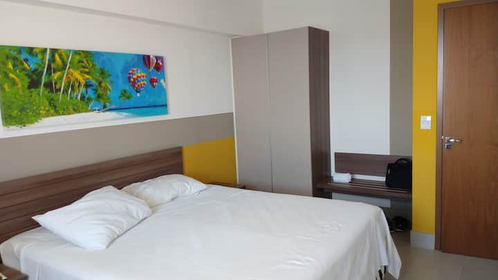 Chumba cha kulala kilicho na kabati, kitanda cha watu wawili, kitanda kimoja, meza mbili za kitanda, kiyoyozi na benchi.