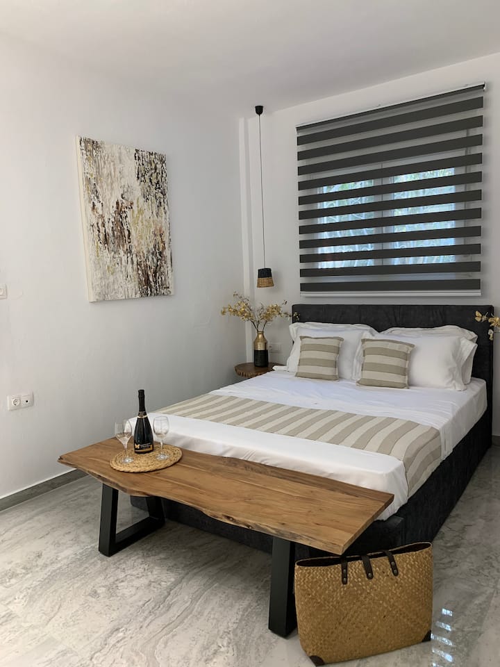 חדר שינה גדול עם עיצוב עץ טבעי שמוסיף תחושה חמימה לחלל.