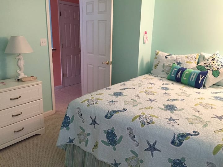 Dormitorio grande con cama tamaño queen, armario completo y TV.