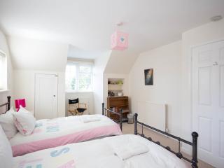 חדר שינה זוגי למעלה עם שתי מיטות יחיד.