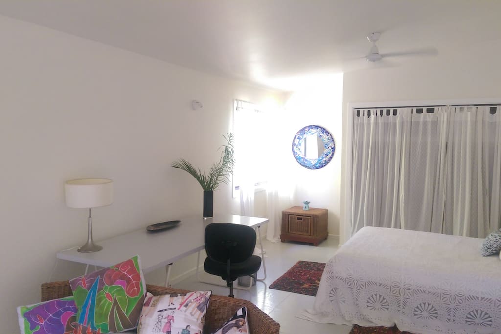 large studio style room with desk and large space for yoga practice