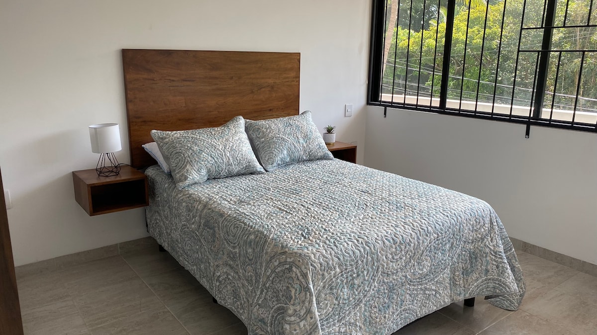 Hlavná spálňa s klimatizáciou s výhľadom na park a tmavé žalúzie, veľký šatník a plne vybavená kúpeľňa vo vnútri spálne.