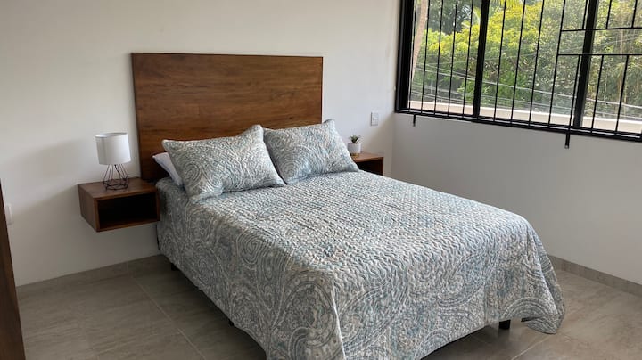 غرفة نوم رئيسية مع مكيف هواء ، تطل على الحديقة والستائر الداكنة ، وخزانة كبيرة وحمام كامل داخل غرفة النوم