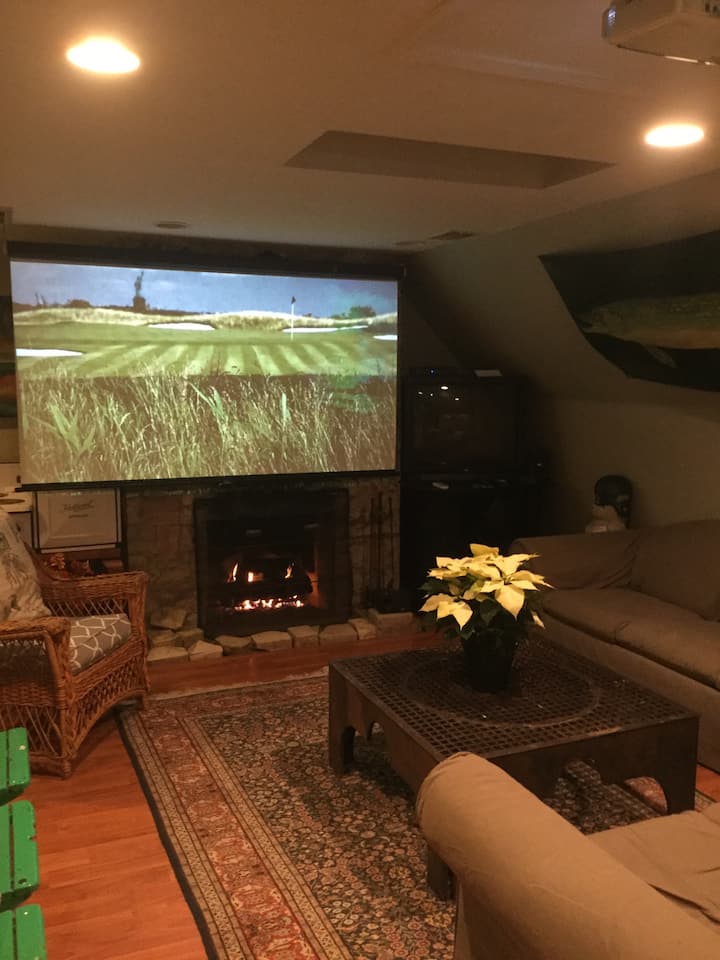 Projection screen TV over fireplace in living area