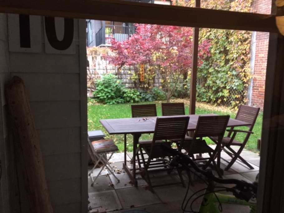 Jardin clos fleuri et verdoyant avec barbecue