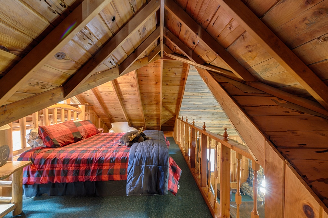 Potkrovlje s bračnim krevetom i pogledom na dnevnu sobu.