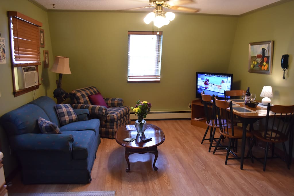 Living room w/ flat screen TV equipped with DISH satellite.