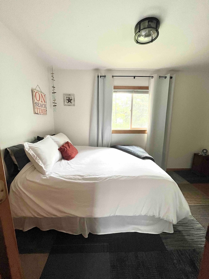 3rd bedroom with queen bed, closet, and blackout curtains. 