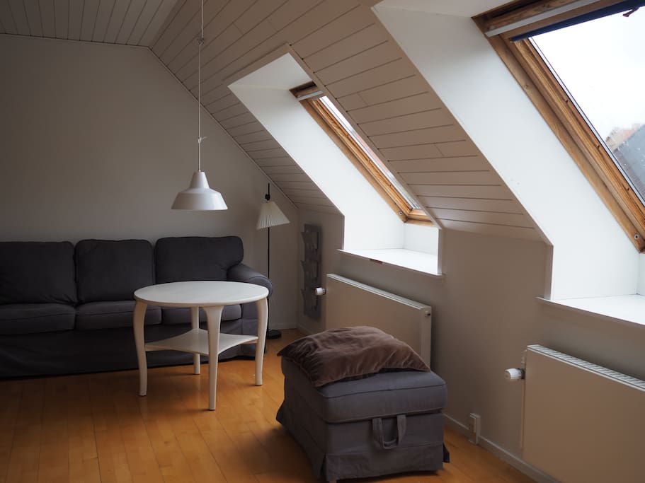Stort værelse med dobbeltseng, barneseng og sofa.