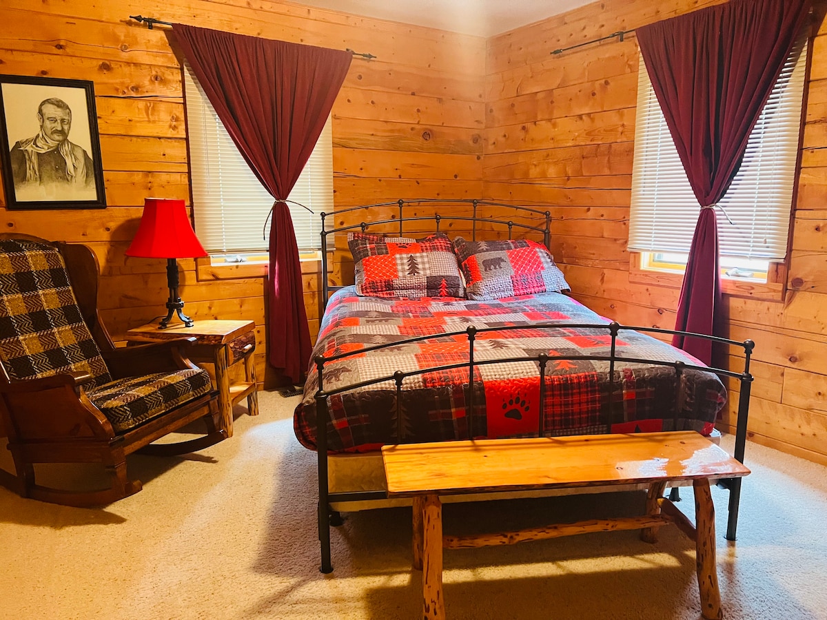 El segundo dormitorio, el nivel principal incluye cama tamaño queen, mecedora, mesita de noche con lámpara y armario.