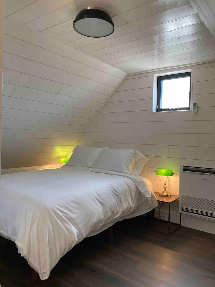 Cama tamaño queen en el loft.
