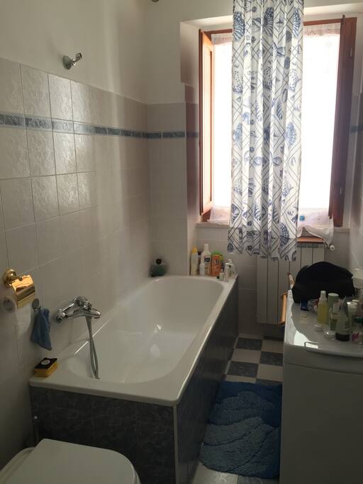 Salle de bain avec baignoire meuble vasque et une machine à laver