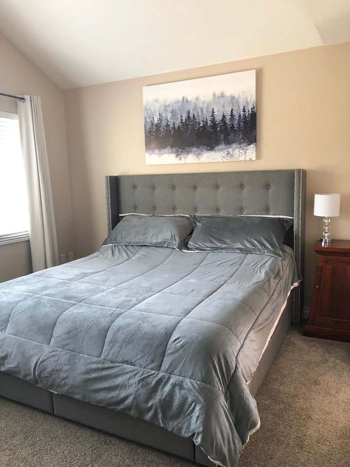 ห้องนอนที่สองขนาดใหญ่ที่เพิ่งปูพรมพร้อมเตียงขนาดคิงไซส์ตู้เสื้อผ้าแบบวอล์คอินและห้องน้ำในตัว