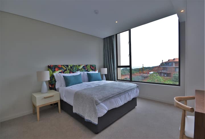main bedroom with queen bed, ensuite b/room,cupboards , tv and partial sea view