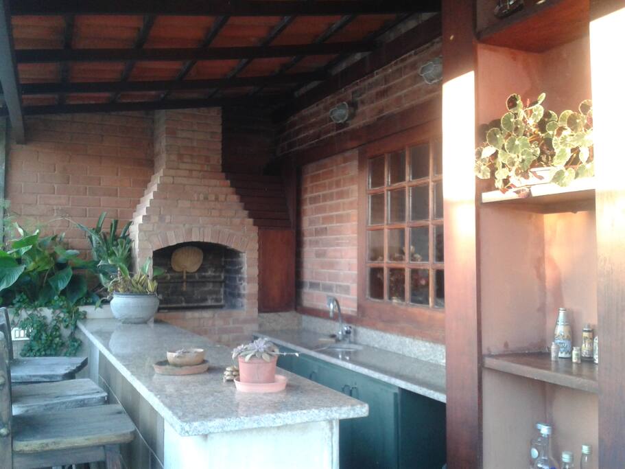 Churrasqueira com bancada e pia de apoio.