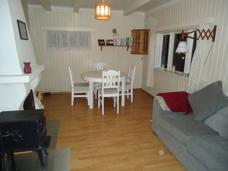 Stue med sofa, peisovn og spisebord