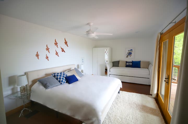 Blue Jay Bedroom - King Bed + 2 Single Beds. The double doors overlook the lake, and lead out onto the top deck.