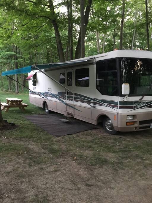 Our 36ft motorhome is nestled beneath the trees in our expansive yard. Picnic table, Umbrella, Private Gazebo