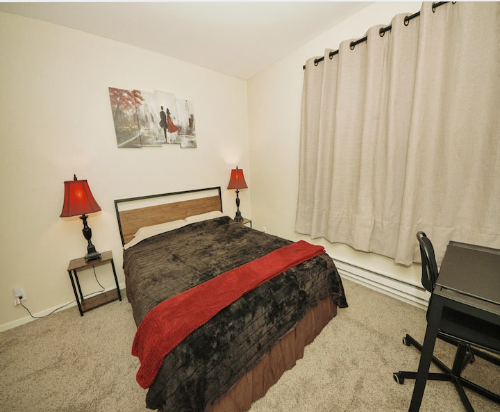 Hoofdslaapkamer met inloopkast, bureau en stoel. 