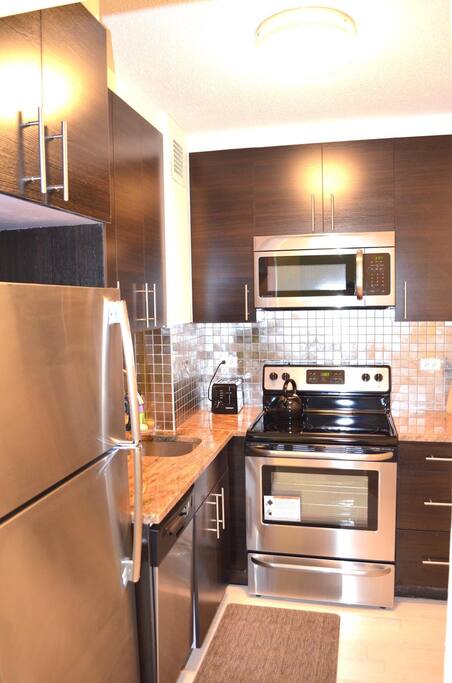 Gorgeous kitchen with appliances, dishes and silverware.