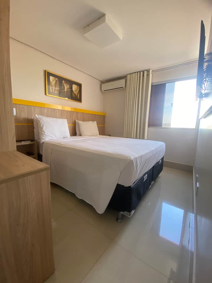 جناح مع سرير بحجم كوين ومكيف هواء وتلفزيون 65 بوصة.