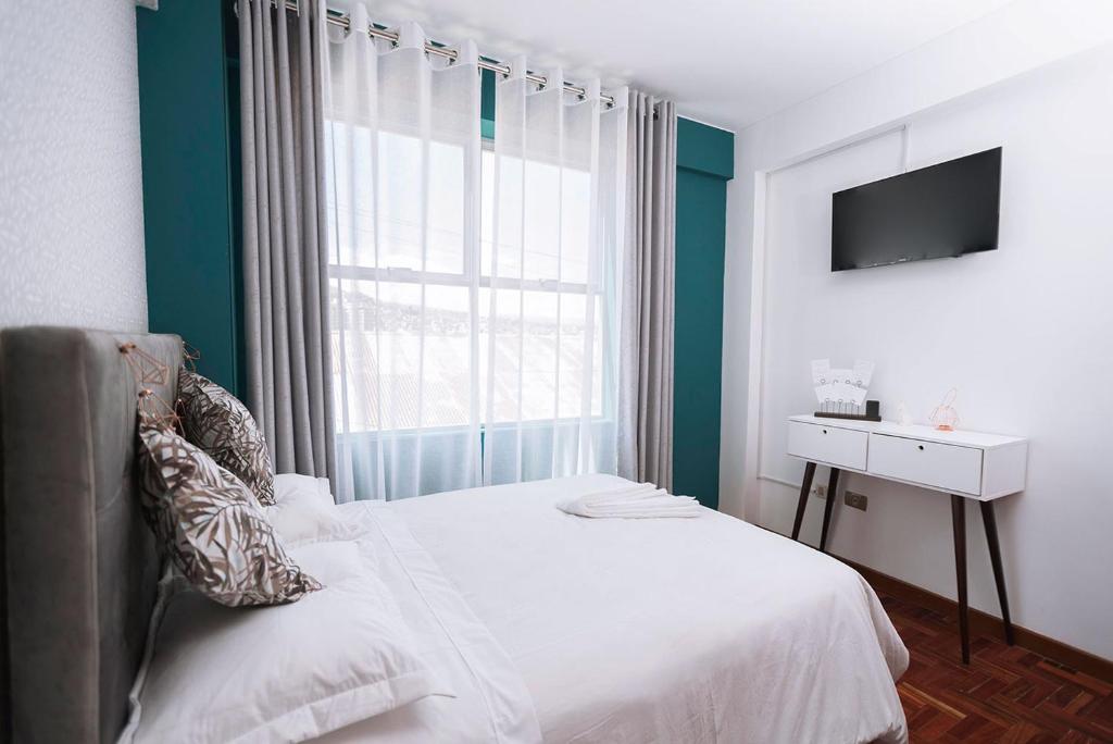 חדר שינה ראשי עם טלוויזיה חכמה בגודל 43אינץ' ומיטת קווין סייז. 