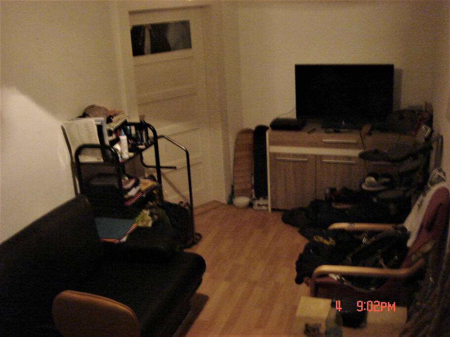 View to the door of the private room. You have a big TV Screen and a commode.
