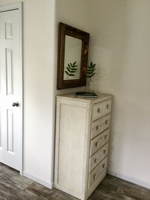 A chest of drawers and closet with wooden hangers for your convenience.