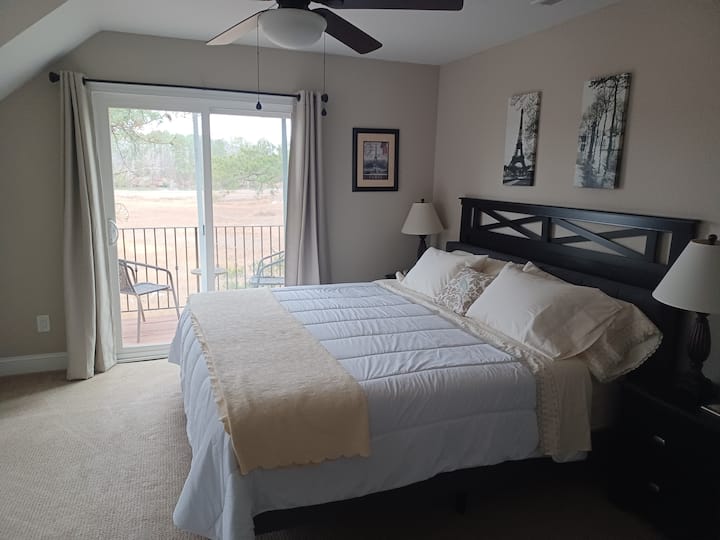 Dormitorio enorme con una cama tamaño king. Disfruta de una vista al agua desde un balcón privado.