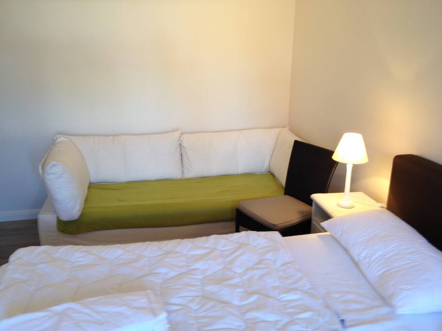das Schlafzimmer mit Boxspringbett und Schlafcouch